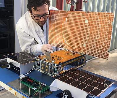 Un ingénieur testant les panneaux solaires d'un cubesat MarCO.