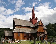 Foto einer Stabkirche mit einem roten Kirchturm