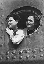 Jewish refugees aboard the SS St. Louis look out through the portholes of the ship while docked in Havana