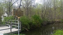 a picture of the marker next to an abandoned, water-filled part of the old canal