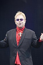 A man wearing a black jacket and red shirt.