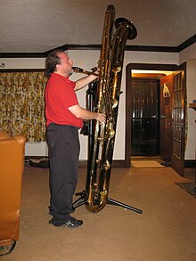 Imagen de hombre tocando el saxofón subcontrabajo de tamaño completo