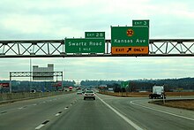 A freeway exit with an overhead sign reading Exit 3 - K-32, Kansas Avenue.