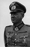 A man wearing a military uniform with an Iron Cross displayed at the front of his uniform collar.