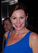American television personality Luann de Lesseps posing for a camera in front of a man.