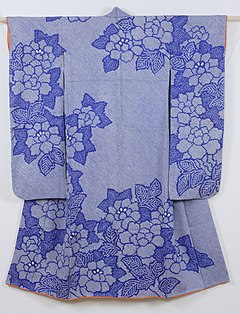 The back view of a medium-blue kimono for a young woman with long sleeves. The kimono has no crests, and is lined in a coral-orange silk fabric.