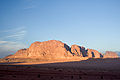 A Wadi Rum monument is illuminated by a fresh sunrise