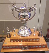 Silver bowl with three handles atop of a two-tiered wooden base with name plates