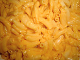 Kraft Easy Mac close-up showing an orange glistening from the liquid cheese sauce that surrounds the noodles