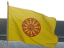 A yellow flag with a saffron-orange flower in the center