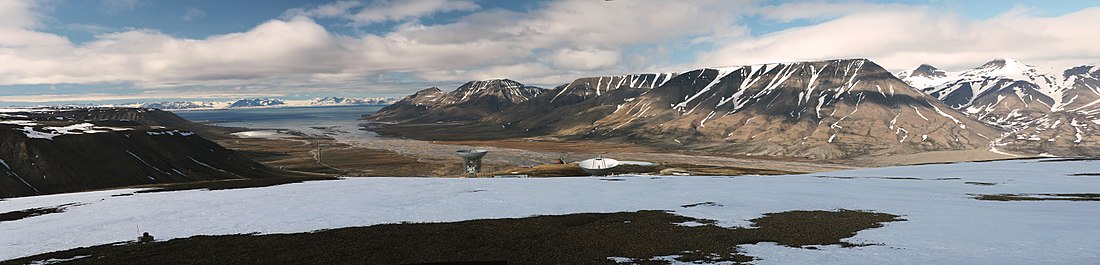 Utsikt från Kjell Henriksen-observatoriet på fjället Breinosa (Gruve 7-fjellet) över Adventdalen. De två antennerna i förgrunden på fjället tillhör Eiscat Svalbard Radar. SuperDARN-antennerna ligger icke synliga till höger om Eiscat-antennerna omedelbart under den snöklädda avsatsen på berget.