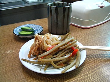 A Japanese appetizer, kinpira gobō, consisting of sauteed gobō (greater burdock root) and carrot, with a side of sautéed dried daikon