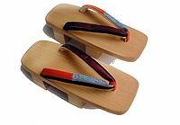A pair of two-teeth men's geta with red and blue straps.