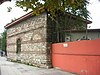 Exterior of the Manastır Mosque, a small building with walls made off alternations of five courses of limestone with four courses of brick