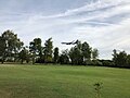 An aeroplane landing at Leeds Bradford Airport, taken from the golf course