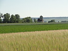 L'église des Istres, entourée de champs, avec en arrière-plan la côte des blancs.