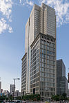 Ground-level view of a boxy, gray high-rise