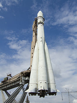 R-7 8K72 "Vostok" permanently displayed at the Moscow Trade Fair at Ostankino; the rocket is held in place by its railway carrier, which is mounted on four diagonal beams that constitute the display pedestal. Here the railway carrier has tilted the rocket upright as it would do so into its launch pad structure—which is missing for this display.