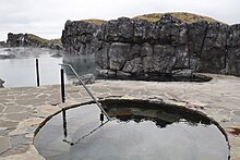 Cold plunge pool with lagoon and rocks in background