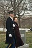 Soldier in dress uniform escorting woman at funeral