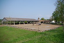 Terrain vu de loin avec des cavaliers à cheval.