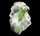 Bright green, twinned crystal of titanite with adularia and minor clinochlore on matrix