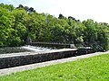 L'écluse de la Couarde sur le Blavet et sa passerelle ; à gauche la falaise boisée du méandre de Castennec (en Bieuzy).