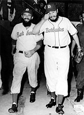 Photographie en noir et blanc de deux hommes barbus portant une tenue de baseball.