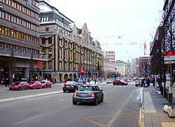 Hamngatan österut vid "Hamngatsbacken" en vinterdag 1955 och samma ställe en vinterdag 2010, "Hamngatsbacken" grävdes bort 1967–1968. Till vänster syns Hästskopalatset och NK, den enda bebyggelsen i den forna backen som överlevde Norrmalmsregleringen.