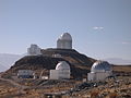 أربعة من تلسكوبات لاسيلا. من الأمام إلى الخلف : قباب المرآة 2و2 متر شميدت، وتلسكوب التقنية الجديدة بمرآة 6و3 متر.