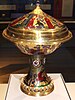 An elaborately decorated enamelled covered gold cup with white tudor roses on the stem and pearls around the base