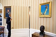 Barack Obama framed by a bust of Martin Luther King Jr. and a painting of Abraham Lincoln