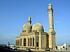 The Bibi-Heybat Mosque, a rectangular building with a somewhat wider and taller central section, with tall windows, three domes and two tall minarets at either end