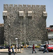 A square stone tower with battlements and bretèches