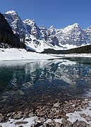 Moraine Lake is still mostly frozen in May and a considerable amount of snow is still in the area and the surrounding mountains.
