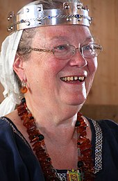 Une femme avec des lunettes et une couronne.