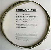 V3Ga superconducting tape (10×0.14 mm cross section). A vanadium core is covered with 15 μm V3Ga layer, then 20 μm bronze (stabilizing layer) and 15 μm insulating layer. Critical current 180 A (19.2 tesla, 4.2 K), critical current density 20 kA/cm2