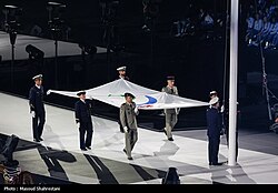 The Paralympic Flag is carried by six individuals