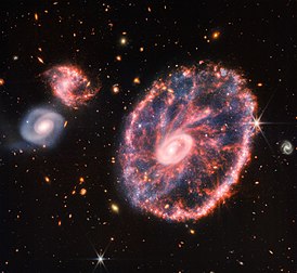 La galaxie de la Roue de chariot, galaxie lenticulaire à anneau située dans la constellation du Sculpteur, photographiée par la caméra NIRCam du télescope spatial James-Webb. (définition réelle 4 685 × 4 312)