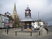 Clock tower in middle of square in Dunstable, Methodist church in background