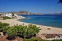 Piperi Strand Naoussa auf Paros, Blick in eine Bucht; auf dem Strand zahlreiche Sonnenschirme, darunter jeweils zwei Sonnenliegen