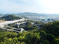 来島海峡第三大橋今治側。中央のループ橋が自転車歩行者道、左上方向に伸びるのが自動車道。原付道は自転車歩行者道の反対外側を通る。奥に見えるのが今治造船。