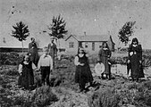 John F. Shelley and his wife stand in the background. In the foreground are the rest of his family: Mary, Tom, Charlotte (Lottie), Docia, Hannah Davis