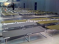 For passengers stranded overnight, secure area at O'Hare International Airport with dimmed lights, cots, pillows, blankets, and toiletries (2008)[29]