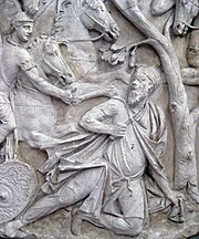 un homme barbu à genou sous un arbre, s'apprête à s'égorger avec un poignard ; un soldat arrive avec deux chevaux et tend la main vers lui.