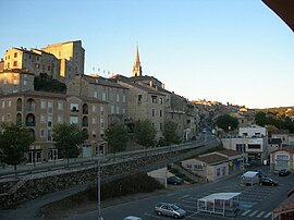 The railway station car park and the D104 road, with the chateau and the church beyond