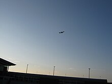 黎明天空背景下的一架正在飛離沙卡國王國際機場的飛機