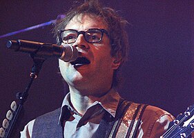 close-up of Steven Page singing and playing guitar onstage