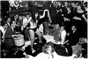 Une femme faisant un strip-tease devant un groupe de personnes amassés dans un restaurant