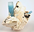 Crystallized white feldspar, with an upright 4 cm aquamarine crystal perched on it